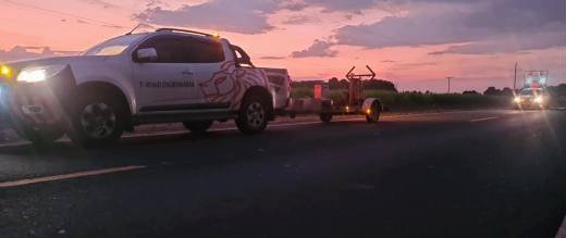 Caminhonete rebocando o FWD em rodovia ao anoitecer